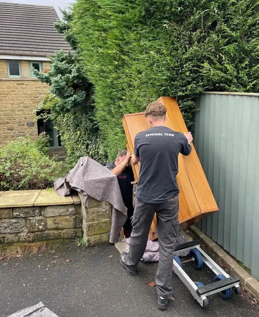 Piano being moved down steps by the team