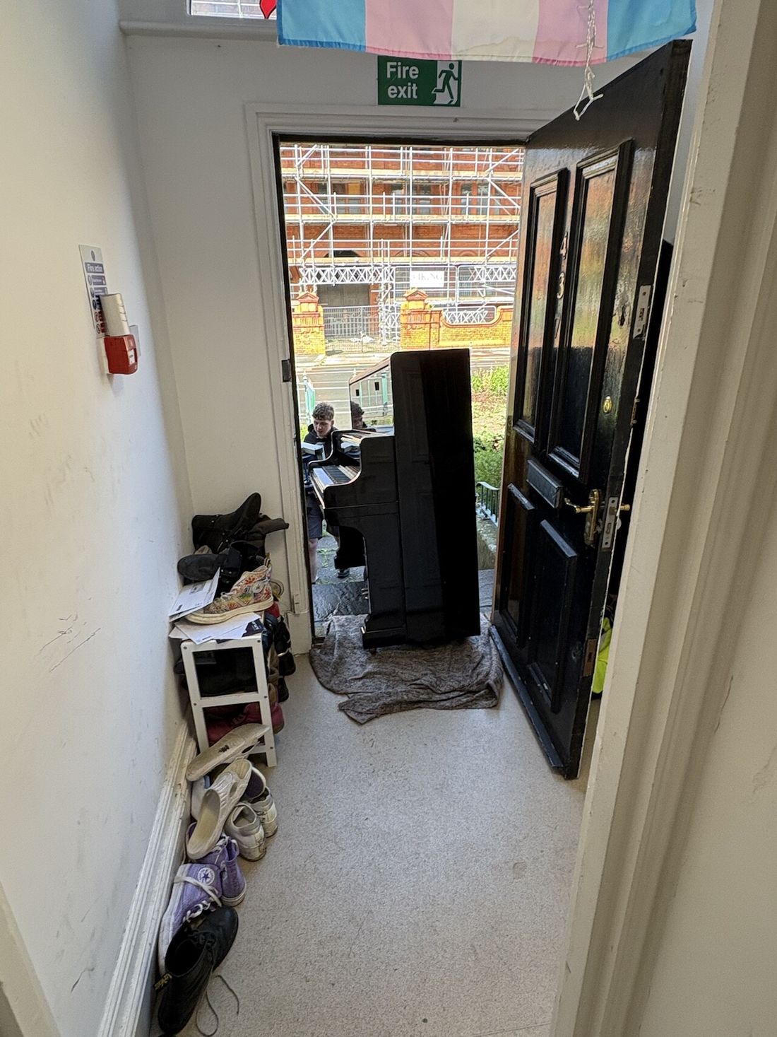 Piano Logistics Manchester mover bringing an upright piano through a doorway